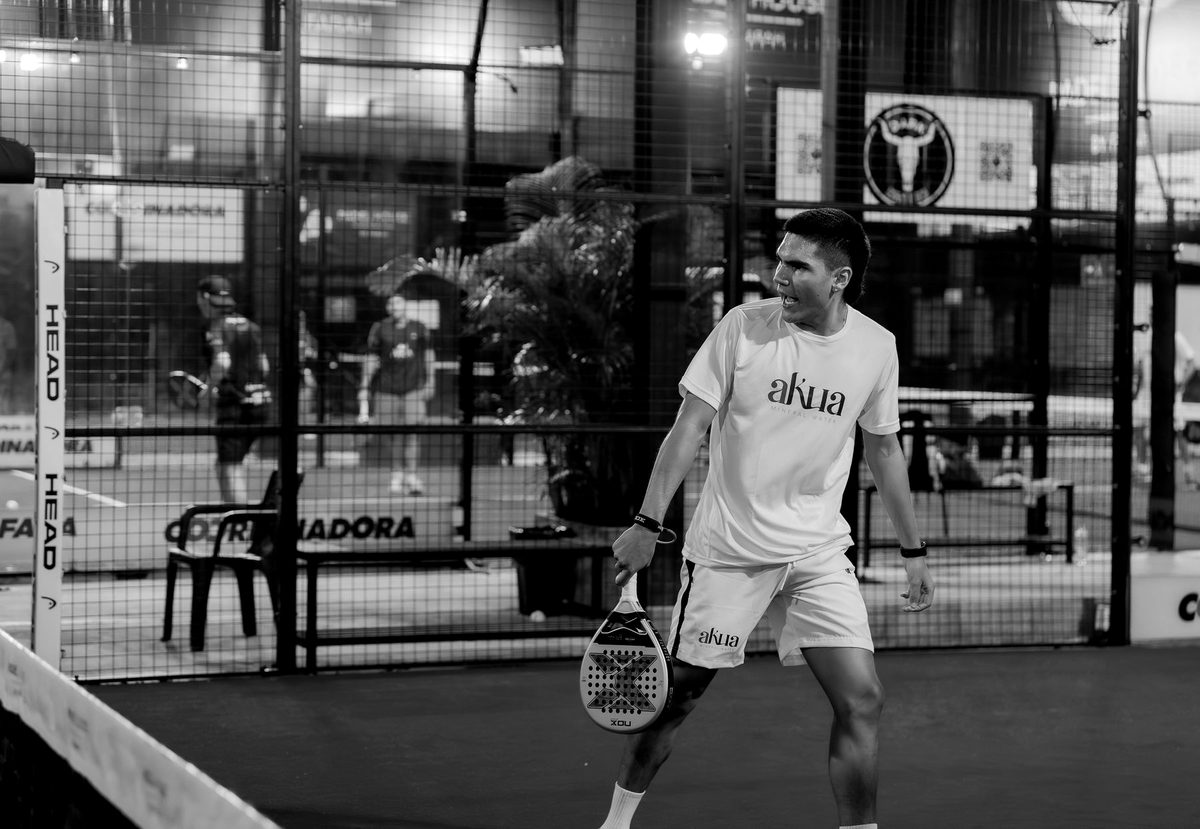 A player mid-rally on an indoor court