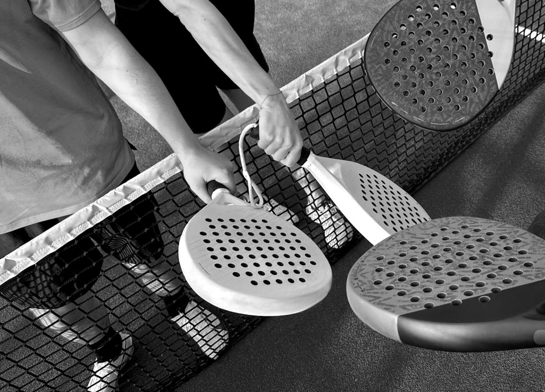 Two players tapping rackets over the net